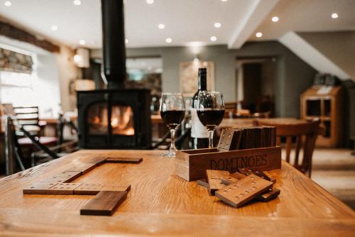 una mesa de madera con 2 copas de vino y una botella de vino en The Wilson Arms, en Torver