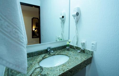 a bathroom with a sink and a mirror at Bogari Hotel in Foz do Iguaçu