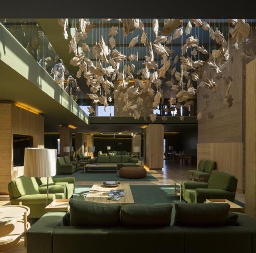 a lobby with a couch and chairs and a chandelier at Monverde - Wine Experience Hotel - by Unlock Hotels in Amarante
