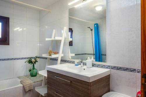 a bathroom with a sink and a mirror and a tub at Can Pota in Portocolom