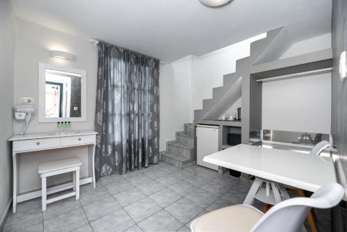 a living room with a table and a staircase at Villa Anemomilos Perissa in Perissa