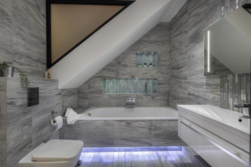 een badkamer met een bad, een toilet en een wastafel bij Luxurious 2 King-size bed flat with Patio in Londen