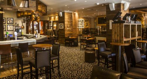 a bar with tables and chairs in a restaurant at Garden Court Sandton City in Johannesburg