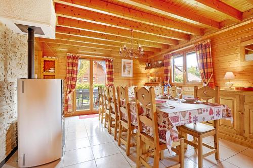 une cuisine avec une table, des chaises et un réfrigérateur dans l'établissement Le Chalet des Cœurs - Avec vue montagne, à Xonrupt-Longemer