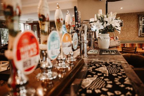 a bar with a counter with glasses and flowers at The Wilson Arms in Torver