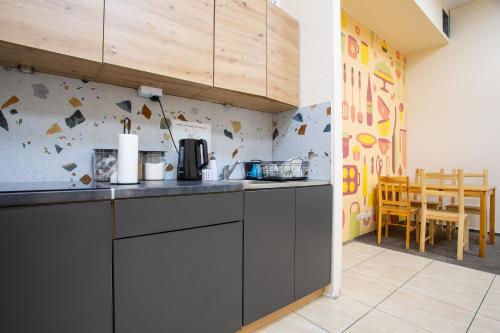 a kitchen with a counter and a dining room at Moon Hostel Wrocław in Wrocław