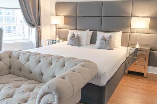 a bedroom with a large bed and a couch at Edinburgh Castle Apartments in Edinburgh
