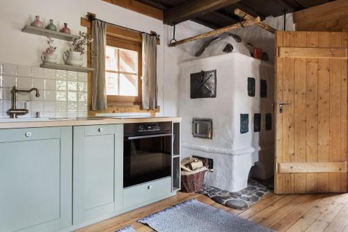 - une cuisine avec des placards blancs et une cuisinière dans l'établissement Das Dorf in der Stadt, à Schladming