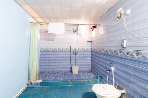 uma casa de banho azul com um WC e um chuveiro em Casa Nova em Palolem