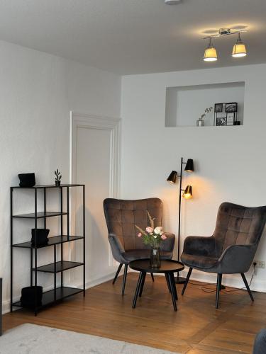 a living room with two chairs and a table at Charmante Altbauwohnung in Erlangen
