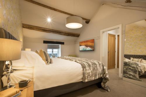 1 dormitorio con 1 cama blanca grande en una habitación en Wharton House Mews in Cartmel, Lake District en Cartmel