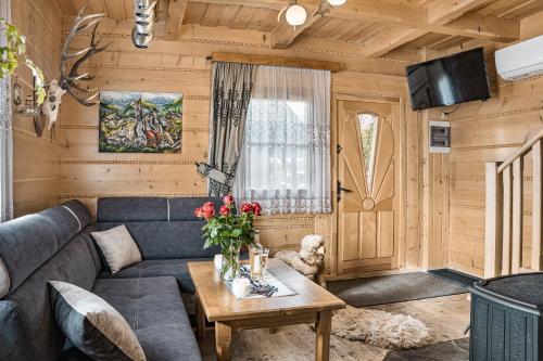 ein Wohnzimmer mit einem Sofa und einem Tisch in der Unterkunft Domki u Adasia in Krośnica
