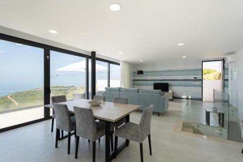a dining room and living room with a table and chairs at Casa Berlenga - By SCH in Famalicão