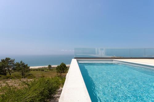 a swimming pool with the ocean in the background at Casa Berlenga - By SCH in Famalicão