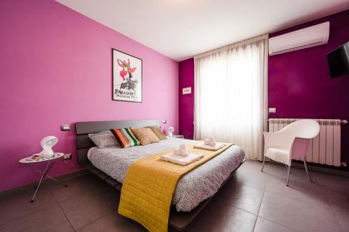 1 dormitorio con paredes moradas y 1 cama con manta amarilla en 3 MIN DAL MARE - Aria Condizionata - Parcheggio Privato"CASA DEI COLORI", en Lido di Camaiore