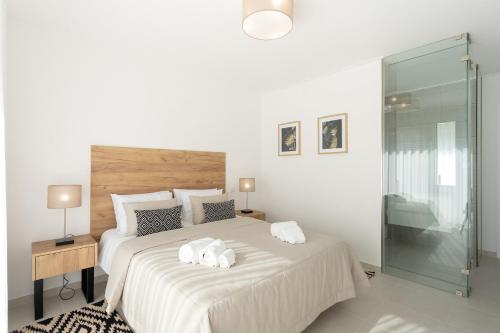 ein weißes Schlafzimmer mit einem Bett mit zwei Handtüchern darauf in der Unterkunft Villa Anita - By SCH in Salir de Porto