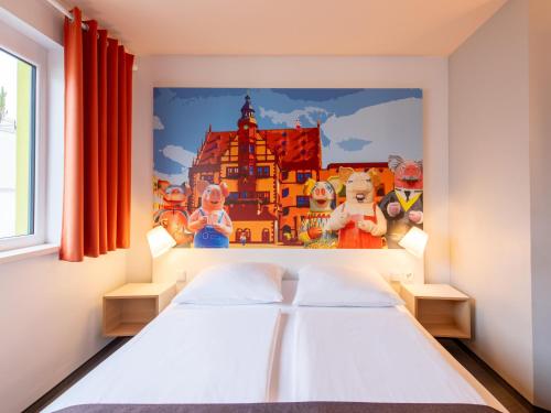 Schlafzimmer mit einem Bett mit Wandgemälde in der Unterkunft B&B Hotel Schweinfurt-City in Schweinfurt