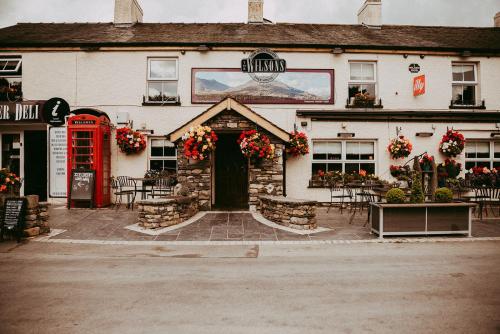a building with a red phone booth in front of it at The Wilson Arms in Torver
