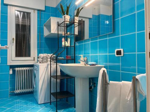 ein blaues Badezimmer mit einem Waschbecken und einem Spiegel in der Unterkunft Giovigemini Apartment in Treviso