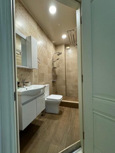 a bathroom with a toilet and a sink and a shower at Iko's Family Apartments in Batumi