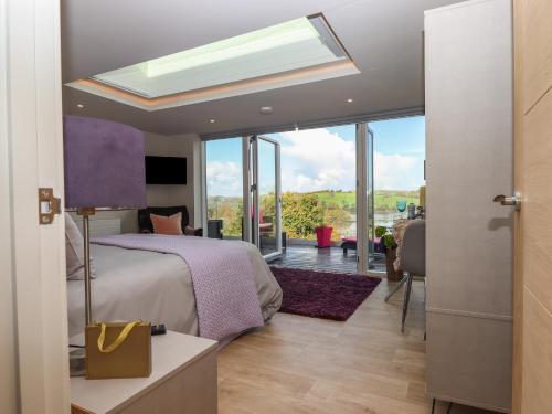 a bedroom with a bed and a large window at Greenslades View in Dittisham