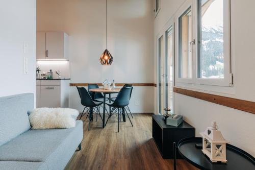 a living room with a couch and a table at Chuenislodge3 neu&stilvoll, 2Balkone, echtes Bijou mit top-Aussicht in Adelboden