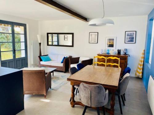 a living room with a table and a couch at Villa la Rabolière quartier Lajarrige à La Baule in La Baule