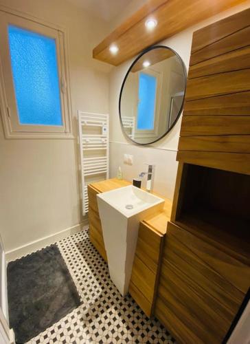 une salle de bain avec un lavabo et un miroir dans l'établissement Villa la Rabolière quartier Lajarrige à La Baule, à La Baule