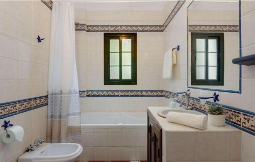 y baño con bañera, aseo y lavamanos. en Cortijo Los Madroños, en Frigiliana