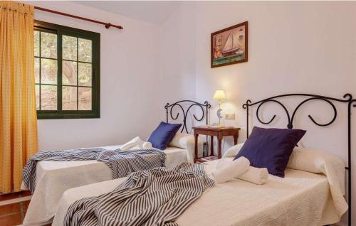1 dormitorio con 2 camas y ventana en Cortijo Los Madroños en Frigiliana