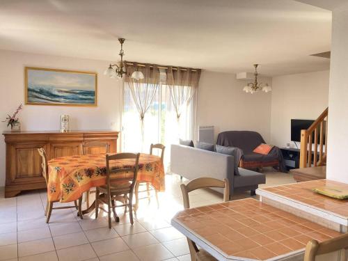 une cuisine et un salon avec une table et des chaises dans l'établissement Villa LES LAURIERS avec terrasse et jardin proche plage, à Narbonne-Plage