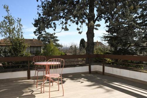 two chairs and a table on a patio with a tree at Casa Maui in Banyoles
