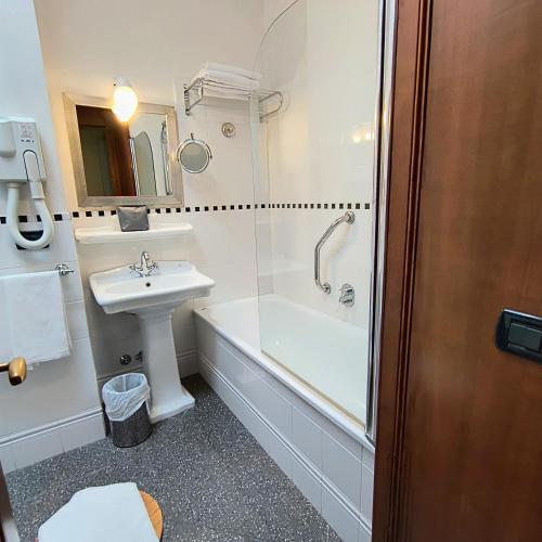 a bathroom with a sink and a toilet and a tub at Hotel Miramonti in Schio