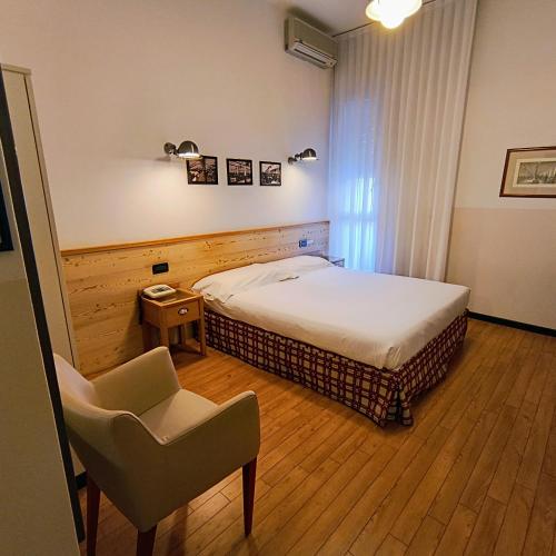 a bedroom with a bed and a chair in it at Hotel Miramonti in Schio