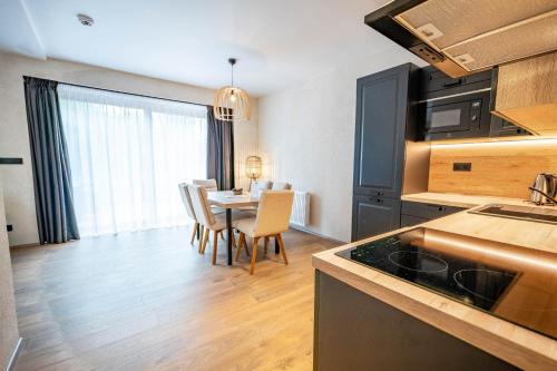 a kitchen and dining room with a table and chairs at Residence Klažary u Žumberka - Terasové apartmány in Kamenná