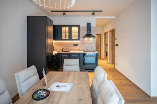 a kitchen and dining room with a wooden table and chairs at Residence Klažary u Žumberka - Terasové apartmány in Kamenná