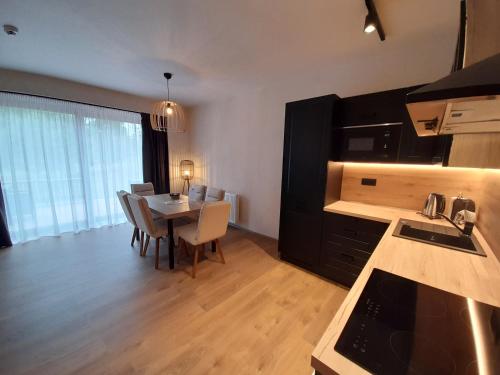 a kitchen and dining room with a table and chairs at Residence Klažary u Žumberka - Terasové apartmány in Kamenná