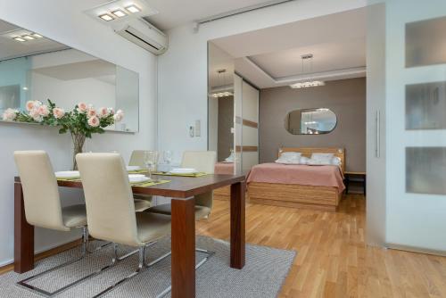 a dining room with a table and a bedroom at Cosy Apartment with Parking in the city centre Warszawa by Renters in Warsaw
