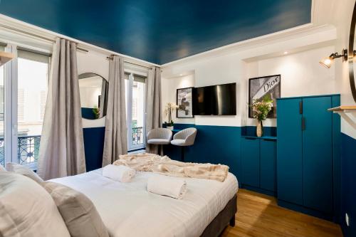 a bedroom with blue walls and a large bed at Cute Studio in the 16th near the Arc de Triomphe in Paris