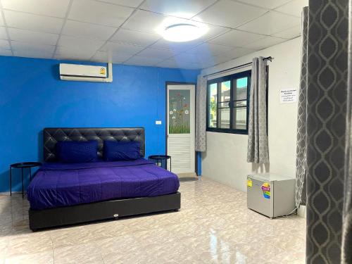 een slaapkamer met een paars bed in een blauwe muur bij U&D guest house in Bangkok