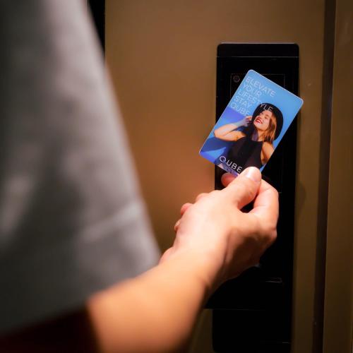 a person holding a book in front of a door at Qube Hotel by 98hospitality in Jakarta