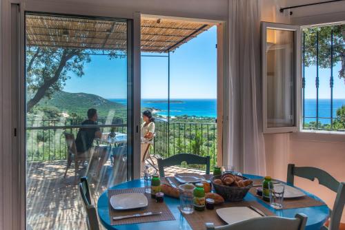 a dining room with a table and a view of the ocean at Résidence Belvedere de Palombaggia in Porto-Vecchio