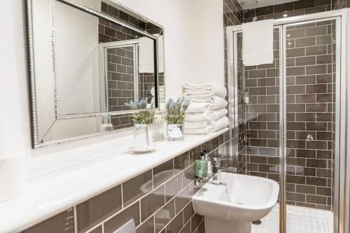 a bathroom with a sink and a mirror at Edinburgh Castle Apartments in Edinburgh