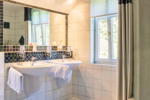 uma casa de banho com 2 lavatórios e um espelho em BnB Rauschenberg em Rauschenberg