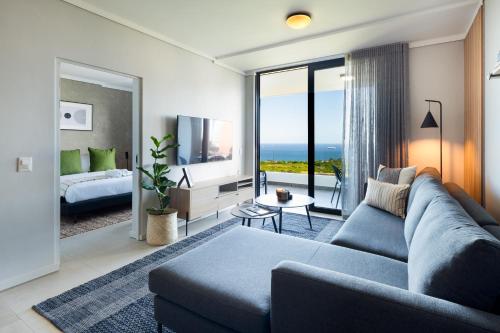 a living room with a blue couch and a television at The Tyne Luxury Apartments in Durban