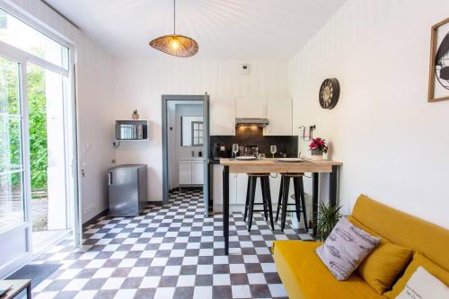 un salon avec un canapé jaune et une cuisine dans l'établissement T2 Hyper Centre Avec *Parking Privé Et Canal Plus*, à Amiens