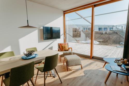 a dining room with a table and chairs and a large window at RELAX APARTMENTS An der Lage Hochgraßnitzberg in Spielfeld