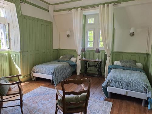 a green room with two beds and a table at Château de la Redortière in Lézignac-Durand