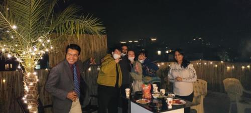a group of people standing on a rooftop at night at Minato Homz in Gurgaon