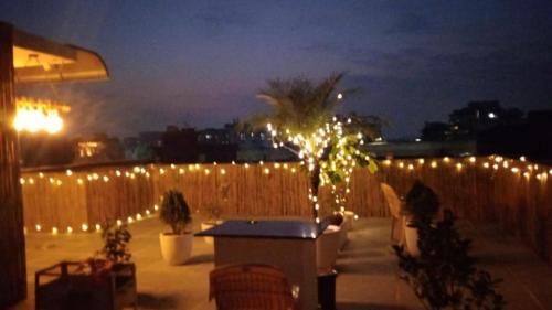 a patio with lights on a fence at night at Minato Homz in Gurgaon